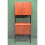 1960's walnut drinks cabinet having two upper doors enclosing glass shelf and mirror back,