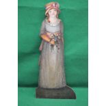 Painted dummy board stick stand in the form of a young lady wearing bonnet with pink bow,