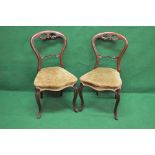 Set of four Victorian mahogany balloon back chairs having carved back rail over padded seat and