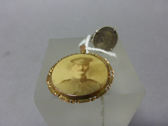 A Silver Ring Set with a Silver George V Coin plus a World War I Yellow Metal Portrait Pendant