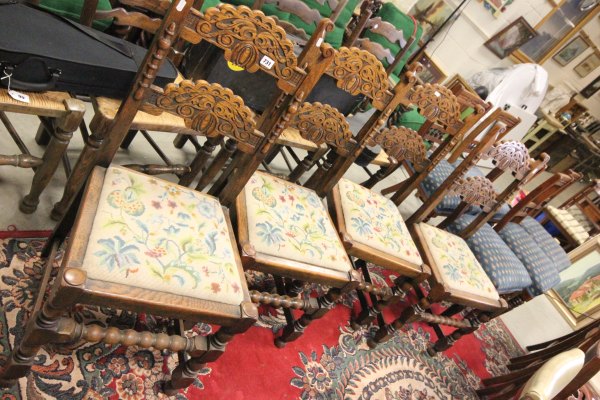 A Set of Four Early 20th century Oak Dining Chairs with carved splats and bobbin cross stretchers