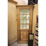 An Antique Pine Corner Cupboard with glazed door and Greek key decorated, raised on plinth base