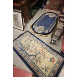 A Chinese 'Mingyuen' Blue Ground Oval Rug 150cm x 80cm together with a similar Rectangular Rug 135cm