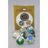 A Collection of Seven Paperweights including Mdina together with a Glass Paperweights Book by