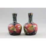 Pair of William Moorcroft Small Bottle Vases, pomegranate pattern, 10cms high, green painted