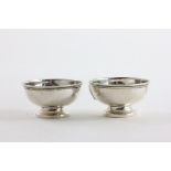 Pair of Silver Circular Salts, plain form raised on footed base, Chester 1929