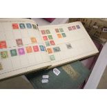 Two stamp albums with a small quantity of world stamps used hinged and a cigarette card album with a