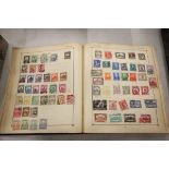 Blue Strand stamp album containing stamps of the world hinged and loose mint and used