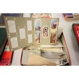 Tin of mixed World Stamps with mint & used some loose, some on paper plus cigarette cards