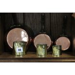 Set of Three Graduating Copper and Brass Small Saucepans and Three Graduating Brass Jugs