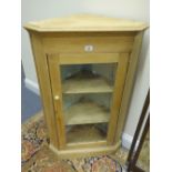 Stripped oak Georgian design corner cupboard with a single glazed door to the front, shelving