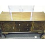 Edwardian period sideboard with oval mirrored back, above a cluster of drawers and cupboards,