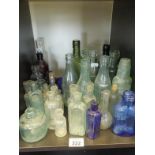 Shelf of assorted advertising glass bottles various sizes and other glass bottle mainly Edwardian