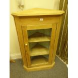 Stripped oak Georgian design corner cupboard with a single glazed door to the front, shelving