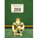 Unusual carved Netsuke, man holding a small coloured fruit clasping a meerkat? Signed to base. Brown