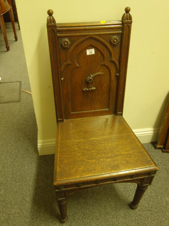 Arts & Crafts period oak hall chair, the back decorated with a hand holding a sabre, on turned front