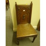 Arts & Crafts period oak hall chair, the back decorated with a hand holding a sabre, on turned front