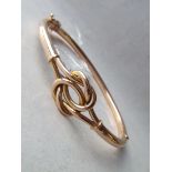 A 15ct gold hinged bangle with knot decoration 9.9g