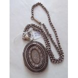 A good Victorian silver hinged locket engraved and chased with foliage on silver neck chain