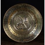 A 17th Century Brass Repoussé Alms Dish.