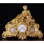 A 19th Century Gilt Metal Mantel Clock surmounted by the figure of a reclining lady above a round