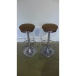 A pair of chrome bar stools with faux su