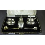 A silver three piece cruet set with two