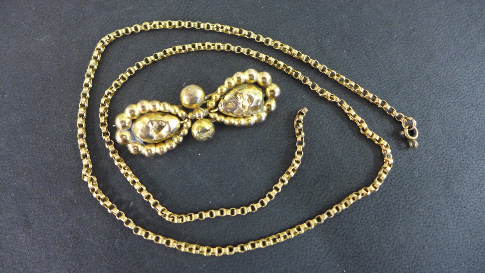 A gold brooch and gold chain tested to o