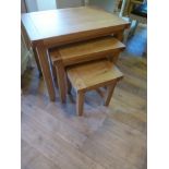 A set of three oak nest of tables