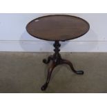 A mahogany side table on a tripod base -