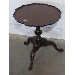A mahogany piecrust top side table on a
