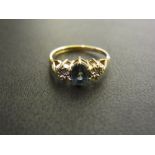 A 9ct gold diamond and topaz three-stone
