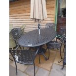 A Bramblecrest Ancona oval table with four chairs, a parasol and base - 160 cm x 110 cm - with