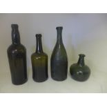 Four antique wine and spirit bottles including an onion shaped bottle and a wind bottle bearing a