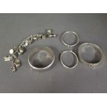 Four silver bangles and a silver charm b