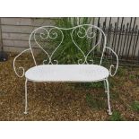 A white painted two seater garden bench