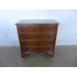 A reproduction walnut four drawer chest, fitted inner tray