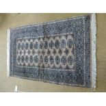 A small Turkmenistan vintage rug of salmon ground with geometric patterns surrounded by boarders -