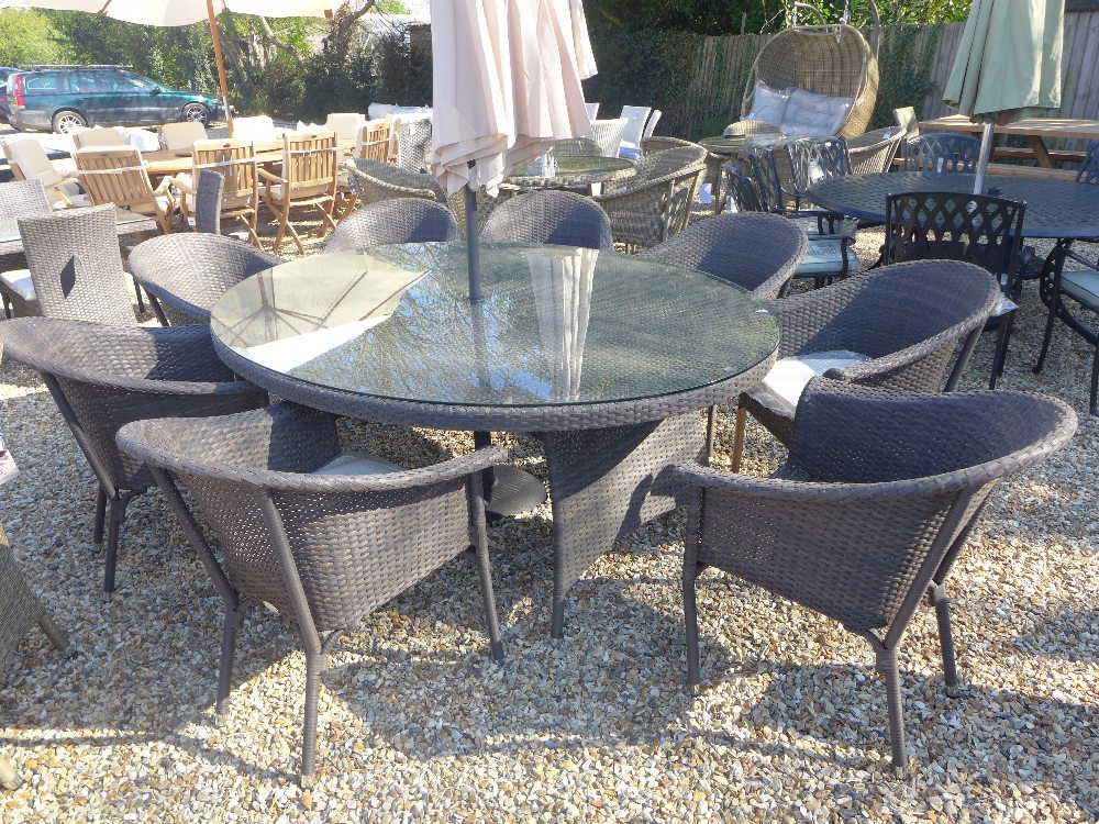 A Bramblecrest Rio elliptical table 220cm x 145cm with eight rio stacking bistro chairs, parasol