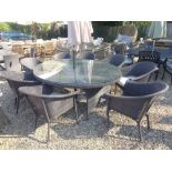 A Bramblecrest Rio elliptical table 220cm x 145cm with eight rio stacking bistro chairs, parasol