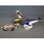 A group of three Royal Crown Derby paperweight s, a Dolphin - missing stopper - a Crab with silver