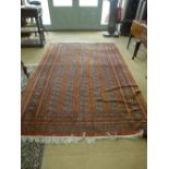 A large Turkmenistan vintage rug of red and brown ground with geometric patterns surrounded by