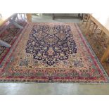 A large Kashan rug with blue field in central medallion and foliate design within pink blue and red
