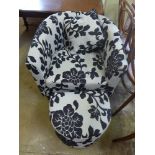 A modern tub armchair upholstered in foliate design with matching footstool