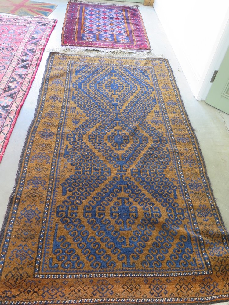 A Belouch Afghan carpet with geometric patterns and borders on brown ground - 200 cm x 107 cm and a