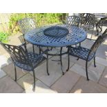 A Bramblecrest aluminium table with a central fire pit and four chairs with no cushions