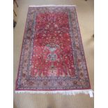 A handknotted wool and silk mix 20th century rug with a red field - 2.12 m x 1.23 m