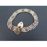 A 9ct gold four-bar gate style bracelet - With two padlock clasps - Hallmarked Birmingham - Length