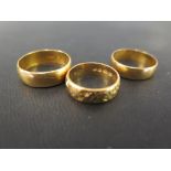 Three 22ct gold band rings - One with textured detail - Hallmarked Birmingham and London - Ring