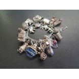 A charm bracelet - Suspending assorted charms - With marks indicating silver - Length 19cms -